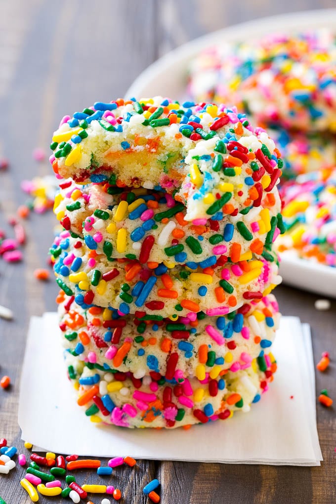 A stack of funfetti cookies with a bite taken out of one.