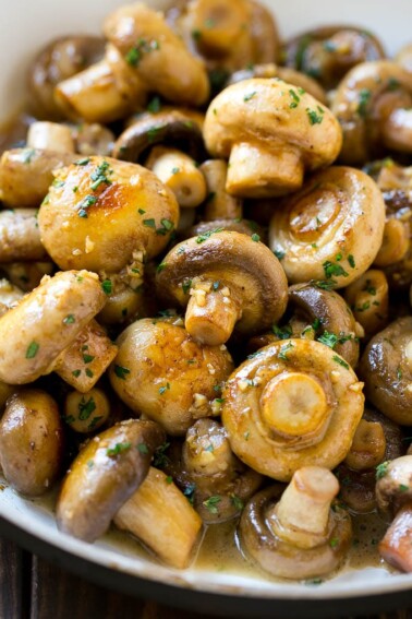 Garlic mushrooms in an herb and butter sauce in a frying pan.