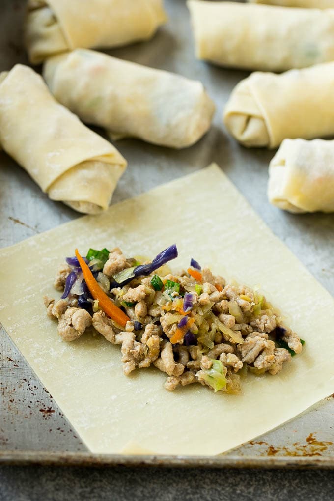 An egg roll wrapper with ground pork and vegetables.
