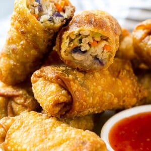 A plate of homemade egg rolls with dipping sauce.
