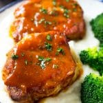 Honey garlic pork chops served over mashed potatoes with a side of broccoli.