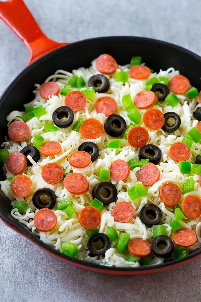 Shredded cheese with pepperoni, green peppers and olives on top.