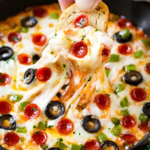 Pizza dip is loaded with all your favorite pizza toppings, baked to golden and gooey perfection and served with baguette slices.