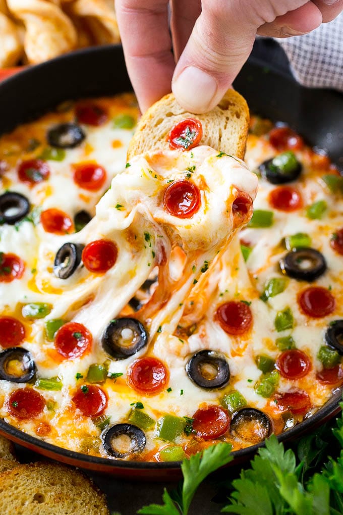 Pizza dip is loaded with all your favorite pizza toppings, baked to golden and gooey perfection and served with baguette slices.