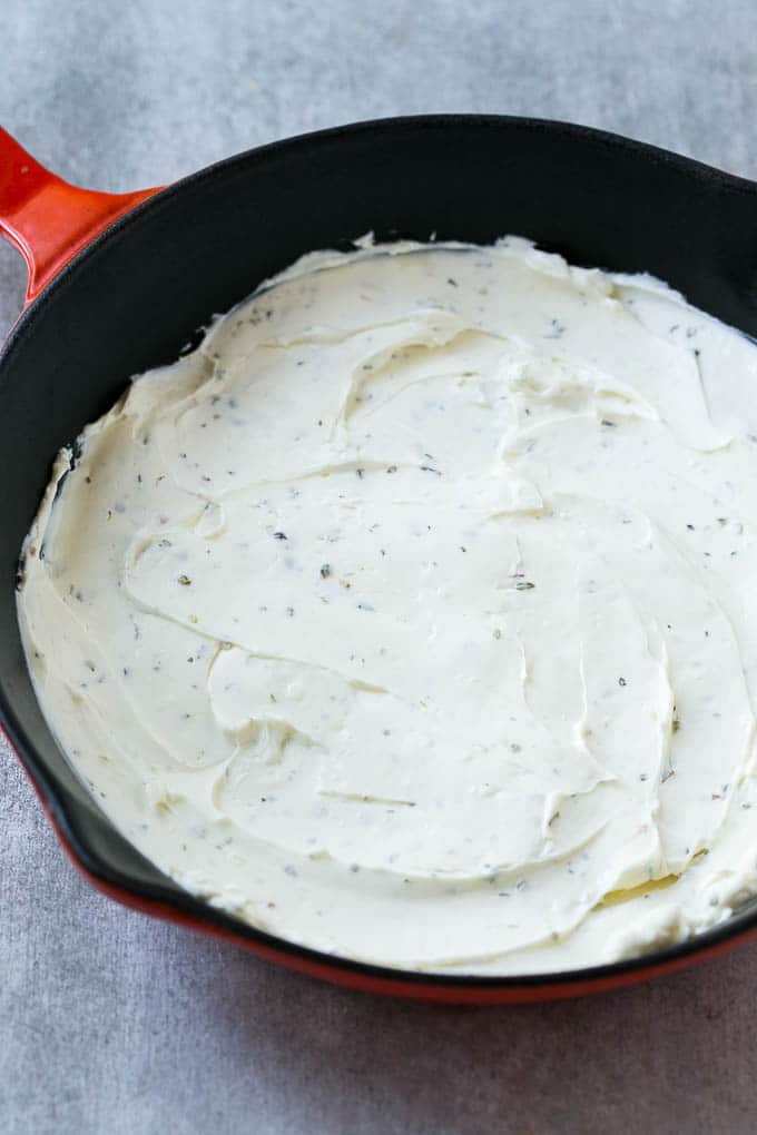 A layer of seasoned cream cheese forms the base of pizza dip.