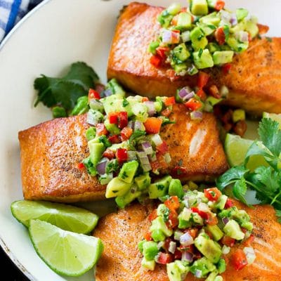 Salmon with avocado salsa in a frying pan.