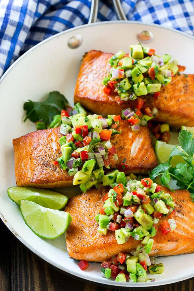 Salmon with avocado salsa in a frying pan.