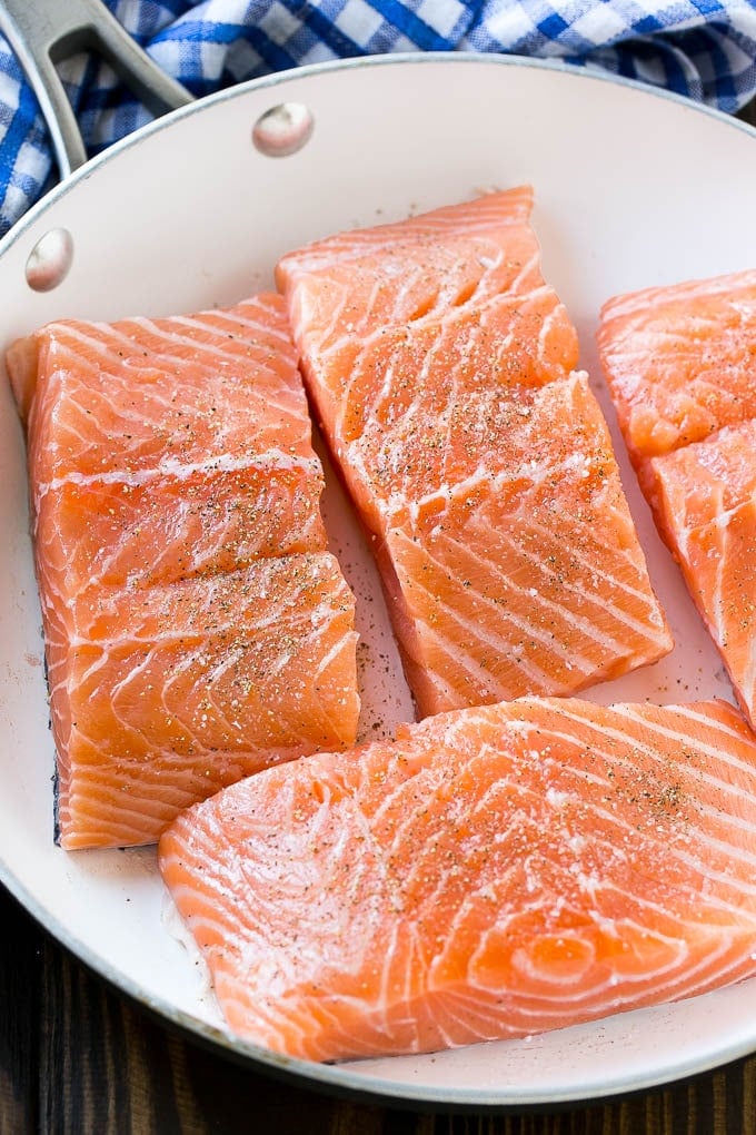 Salmon fillets in a frying pan, ready to be cooked.