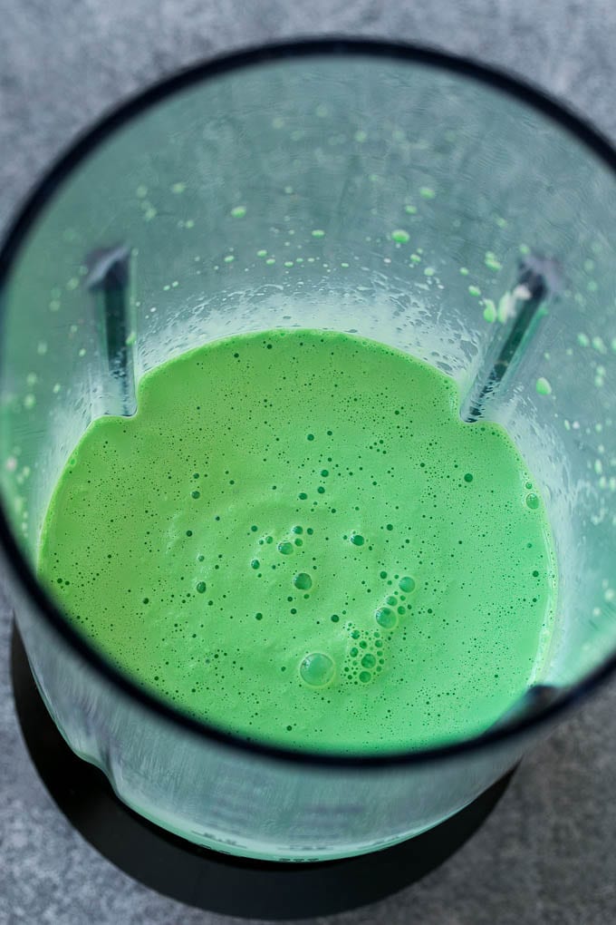 Green milkshake in a blender.