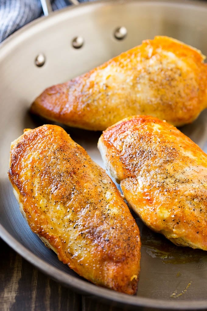 Seared chicken breasts in a frying pan.