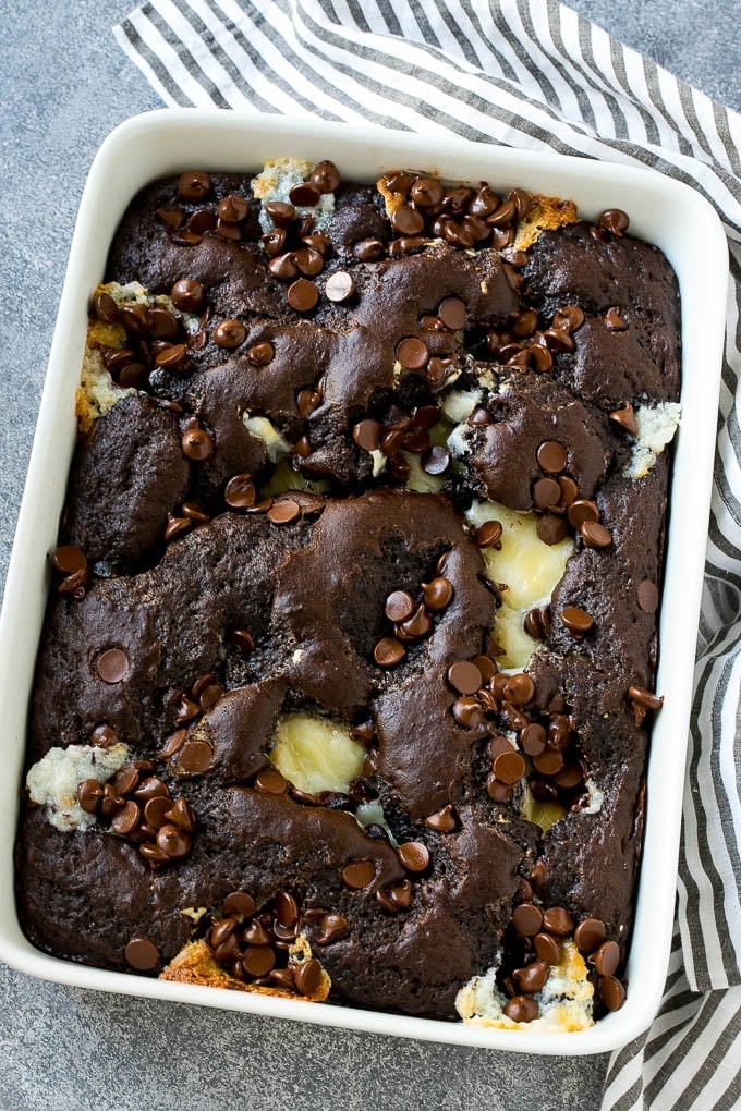 A pan of earthquake cake topped with dollops of cream cheese and chocolate chips.