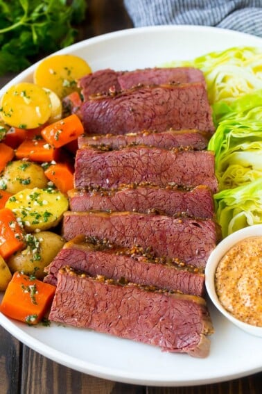 A platter of slow cooker corned beef, cabbage wedges, potatoes and carrots.