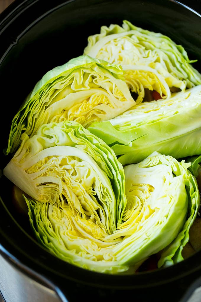 Cabbage wedges inside a crock pot.
