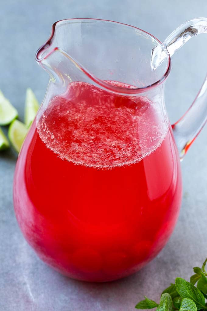 Soda, cherries, cherry juice and limeade in a pitcher.