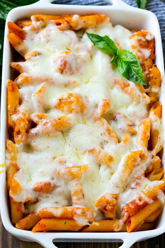 A pan of baked chicken parmesan pasta covered in melted cheese.