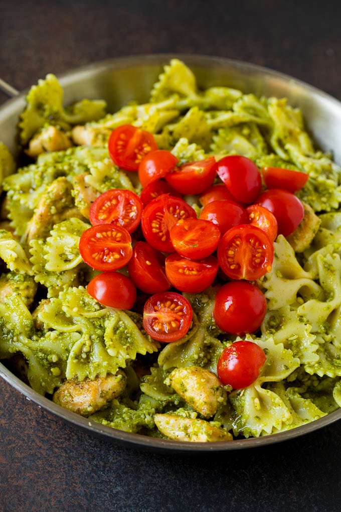 Chicken and pasta topped with cherry tomatoes.