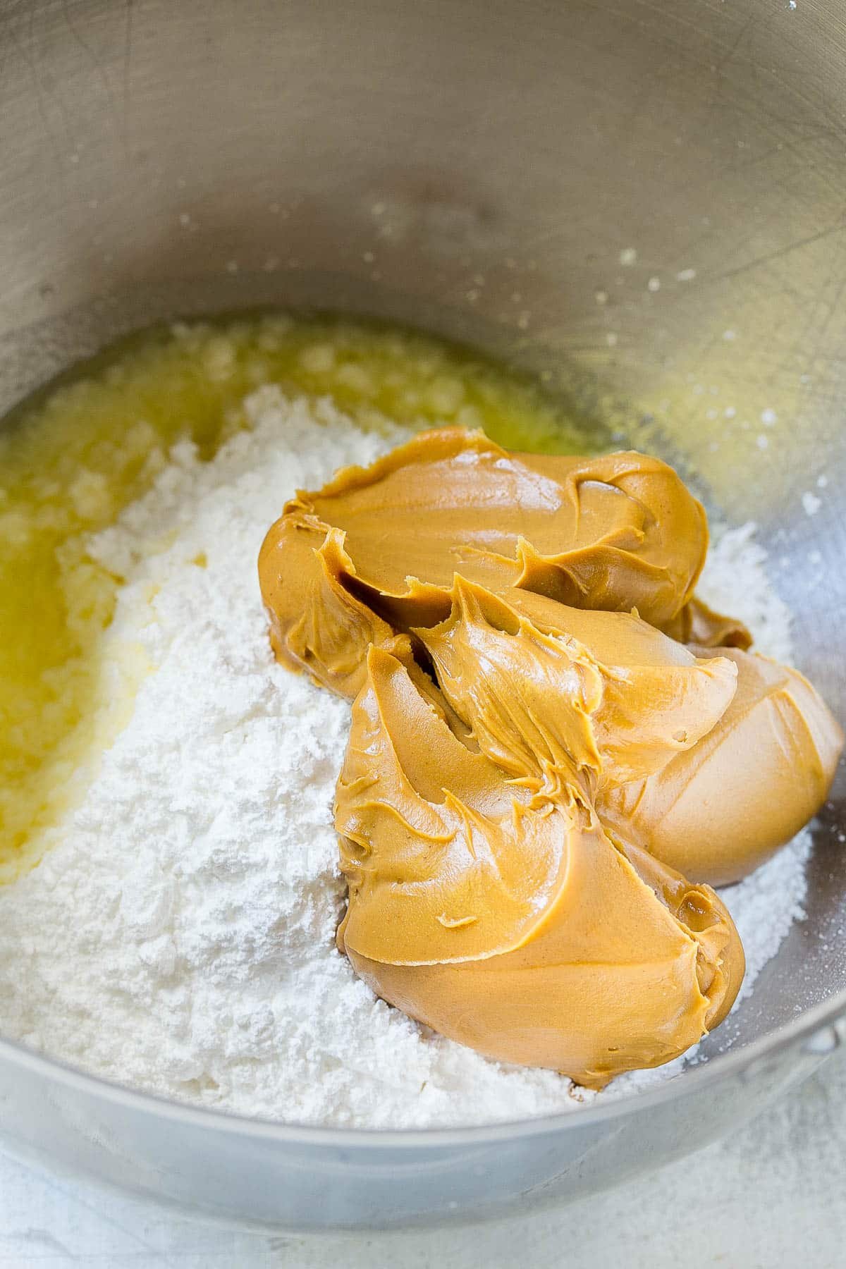 Peanut butter, powdered sugar, water and butter in a bowl.