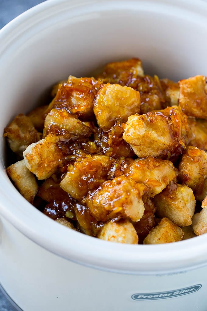 Breaded chicken in a slow cooker coated with a sweet and savory sauce.