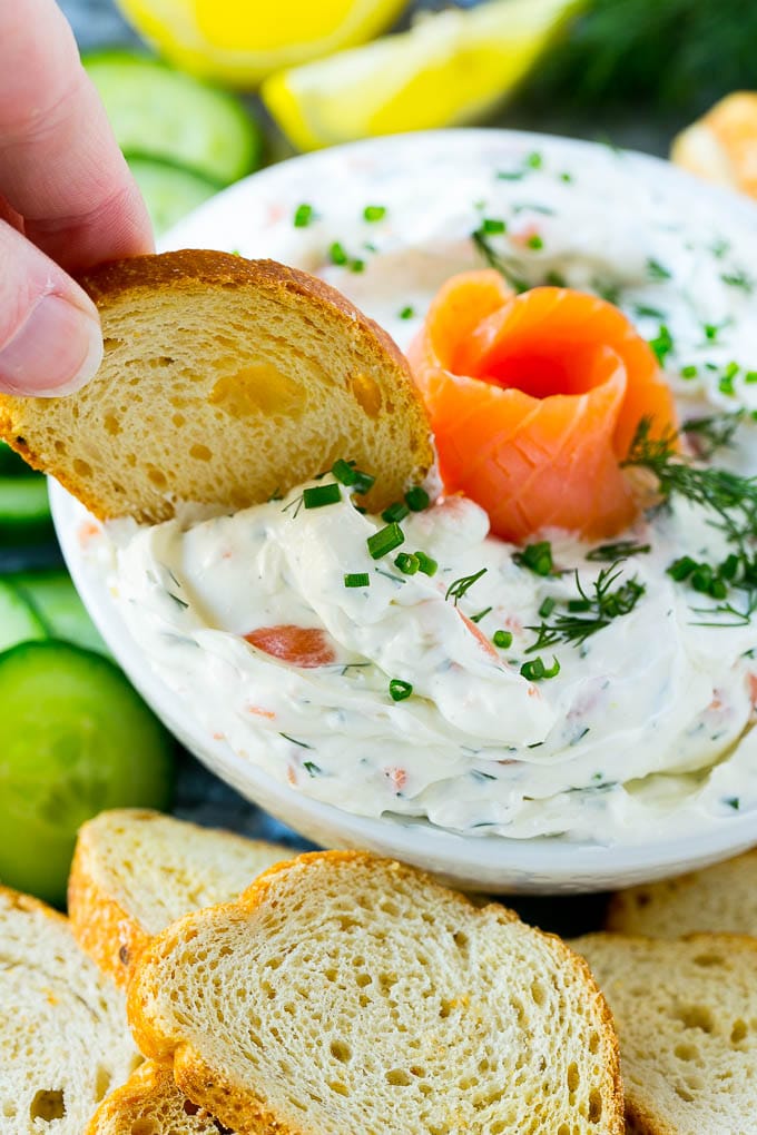 A bowl of smoked salmon dip with crostini for dipping.