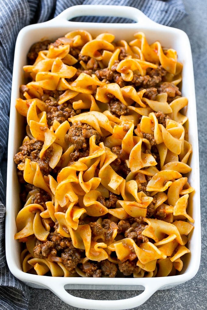 Ground beef and egg noodles tossed in tomato sauce, inside a baking dish.