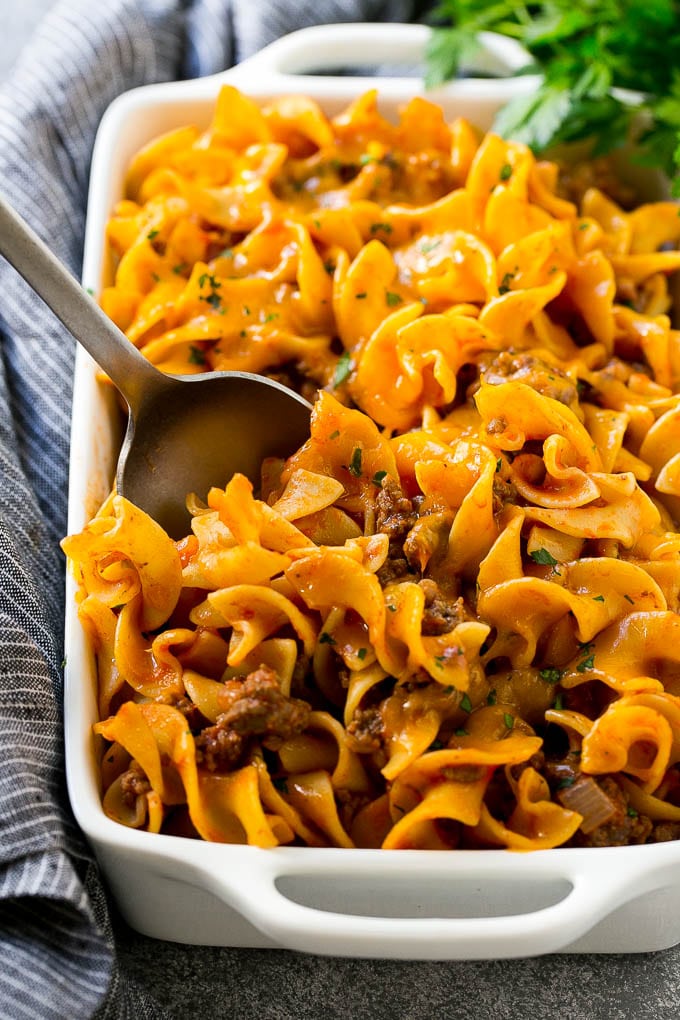 A pan of beef noodle casserole with a serving spoon in it.