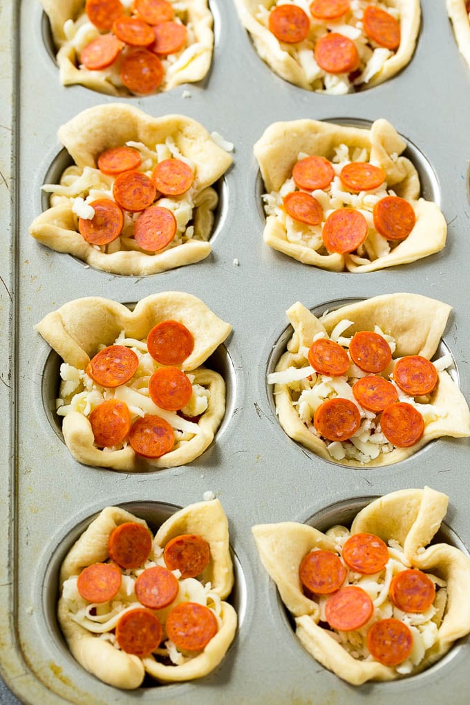 Unbaked dough cups filled with cheese, sauce and pepperoni.