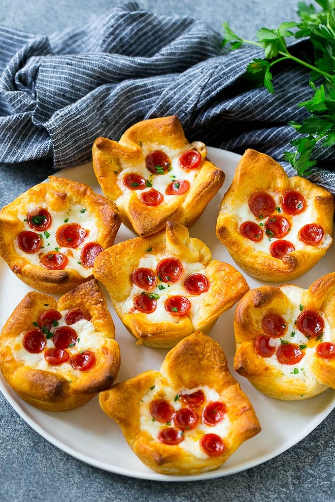 Pizza muffins on a serving plate garnished with parsley.