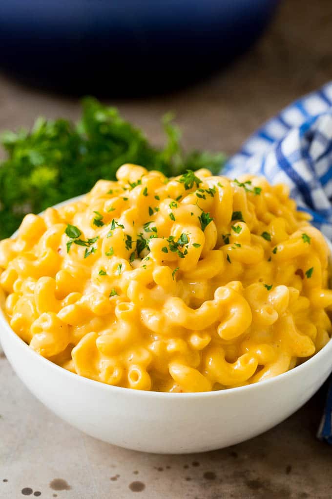 A serving bowl of stovetop mac and cheese topped with parsley.