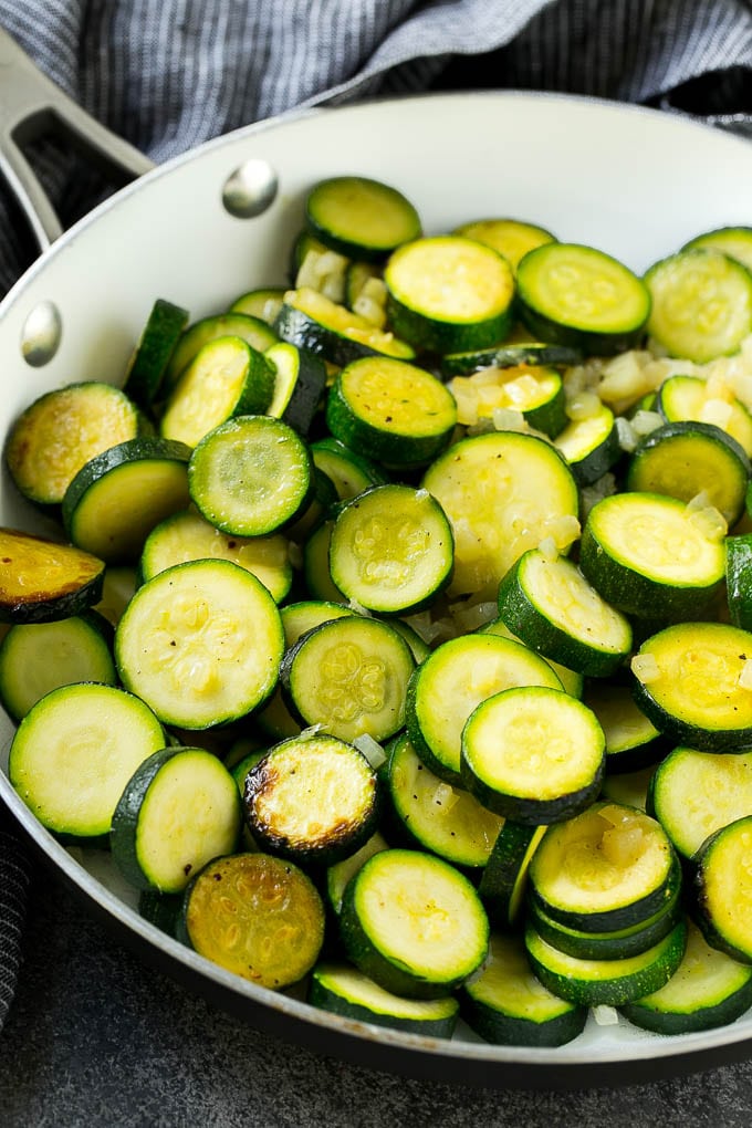 Sauteed zucchini and onions in a skillet.