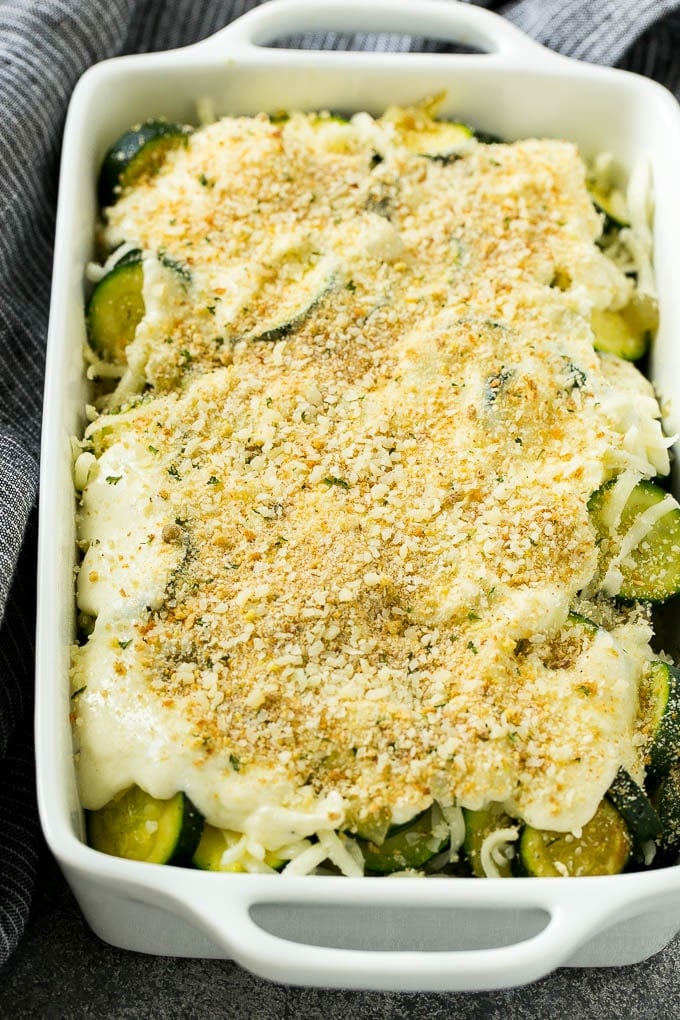 Zucchini gratin with layers of cheese, sauce and breadcrumbs, ready to go into the oven.