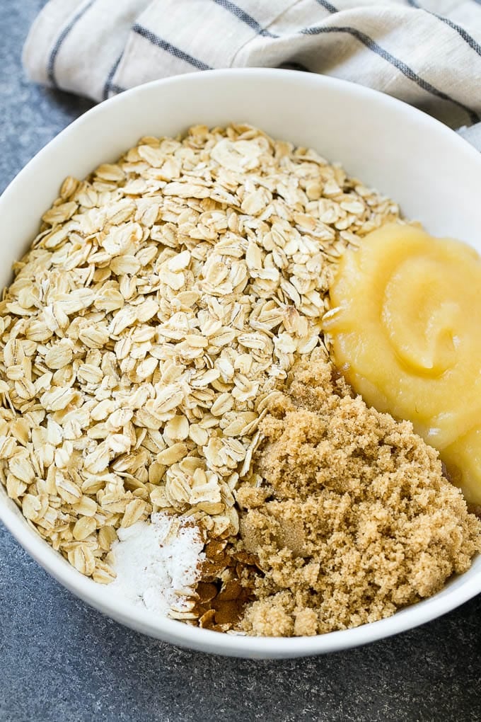 A bowl of oats, applesauce, brown sugar, cinnamon and baking powder.