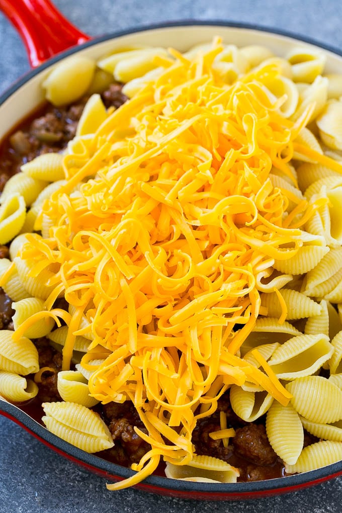 Ground beef in tomato sauce with pasta and shredded cheese.