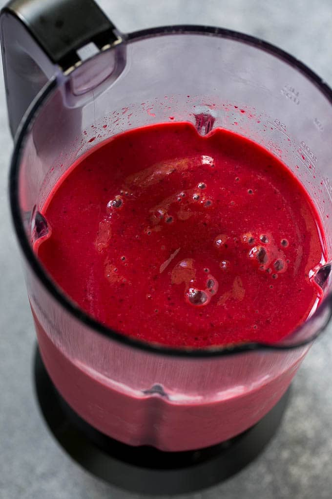 A blender full of cherry smoothie.