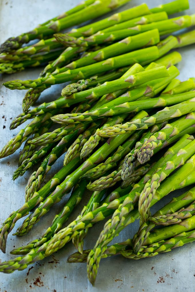 Fresh raw asparagus stalks on a sheet pan.