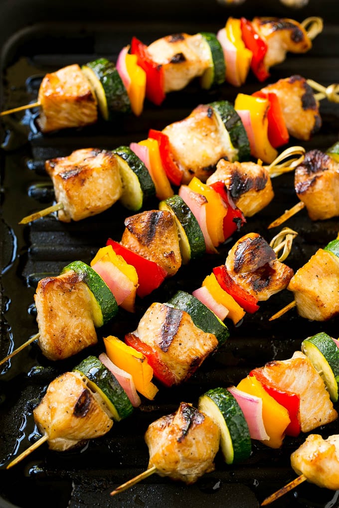 Cooked grilled chicken kabobs on a grill pan.