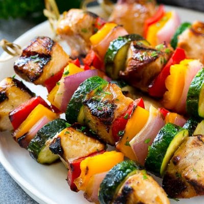A plate of grilled chicken kabobs made with marinated chicken and colorful vegetables.