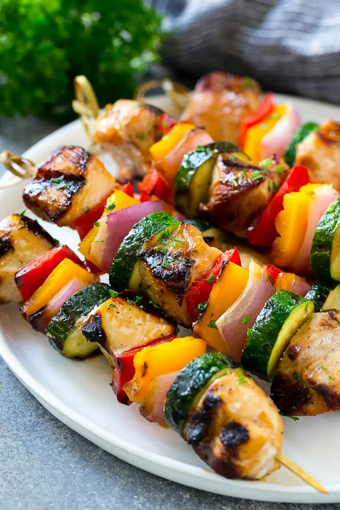 A plate of grilled chicken kabobs made with marinated chicken and colorful vegetables.