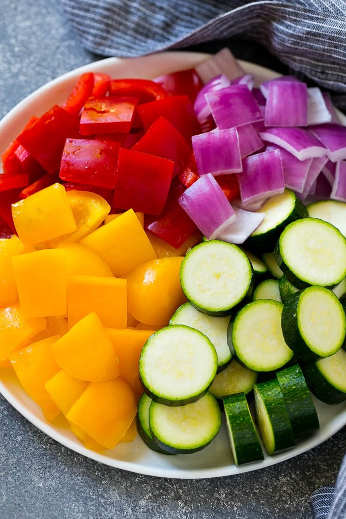 Zucchini, red peppers, yellow peppers and red onion for grilled chicken skewers.