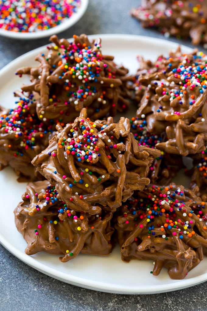 A plate of haystack cookies topped with rainbow sprinkles.