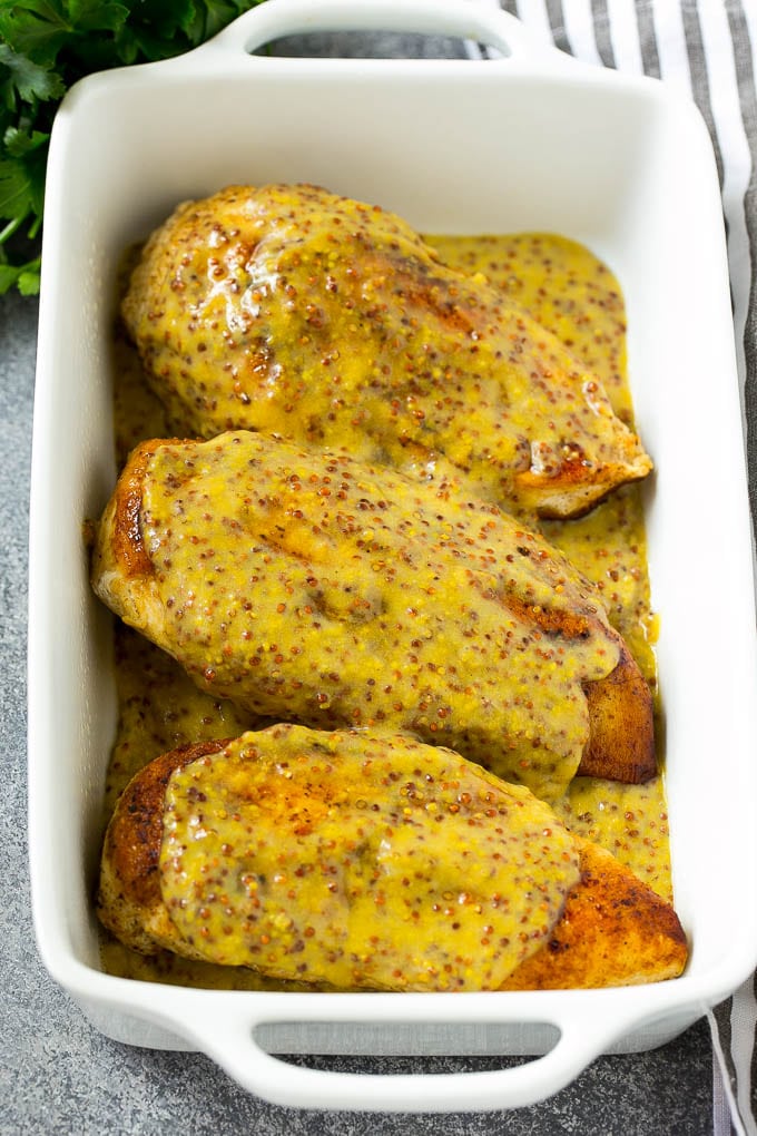 Chicken breasts in a baking dish topped with honey mustard sauce.