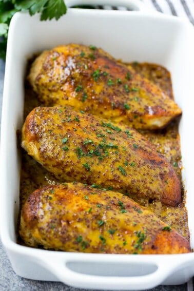 Baked honey mustard chicken garnished with chopped parsley.