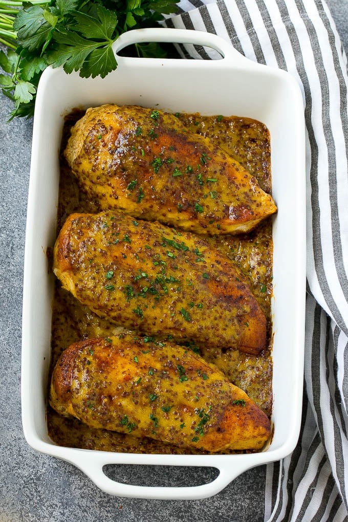 A baking dish of honey mustard chicken breasts.