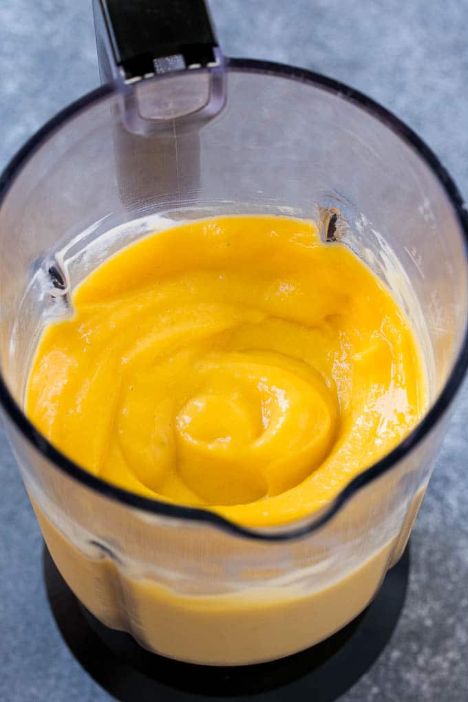 A blender full of mango smoothie.