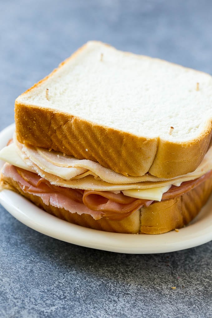 An uncooked Monte Cristo sandwich with bread, ham, turkey and cheese.