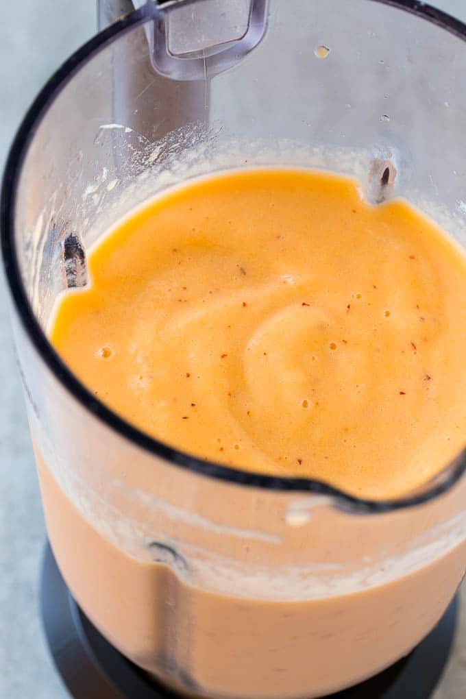 A blender full of peach smoothie.