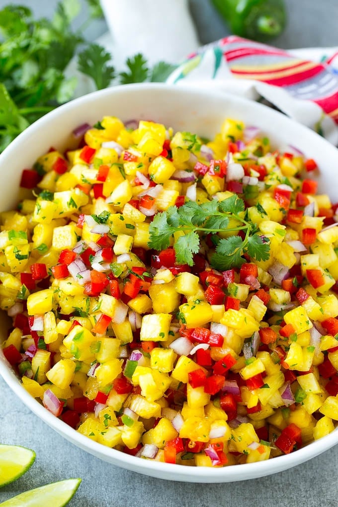 A bowl of pineapple salsa garnished with fresh cilantro.