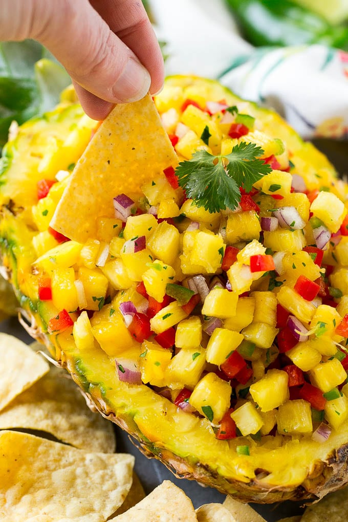 Pineapple salsa with a chip scooping some out.