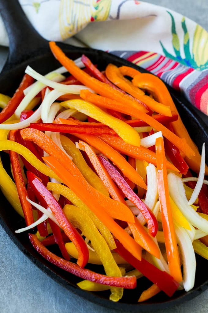 Bell peppers and onions in a skillet.