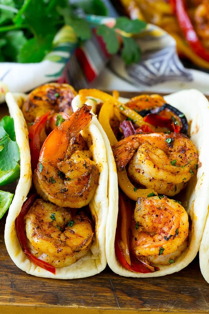 Shrimp fajitas inside of flour tortillas.