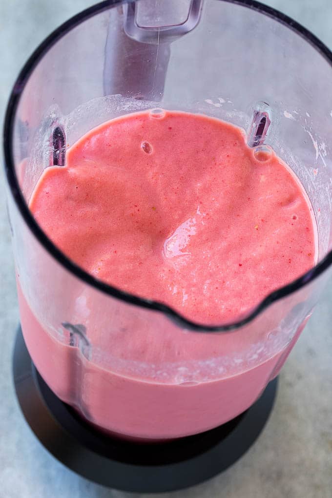 Strawberry banana smoothie in a blender.